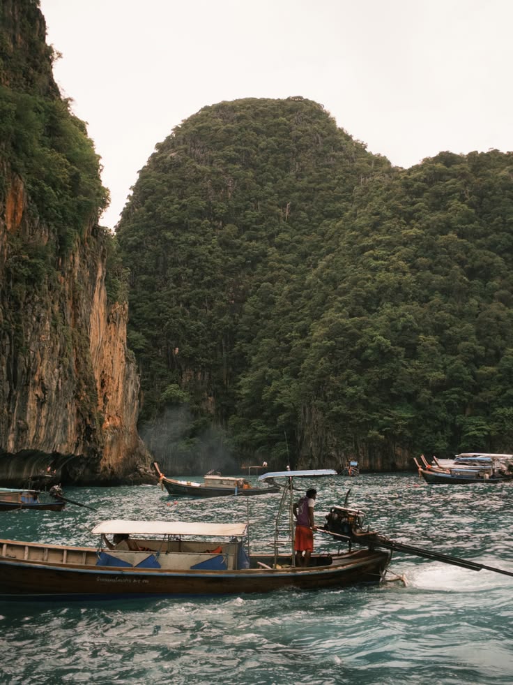 Longtail boats under limestone cliffs